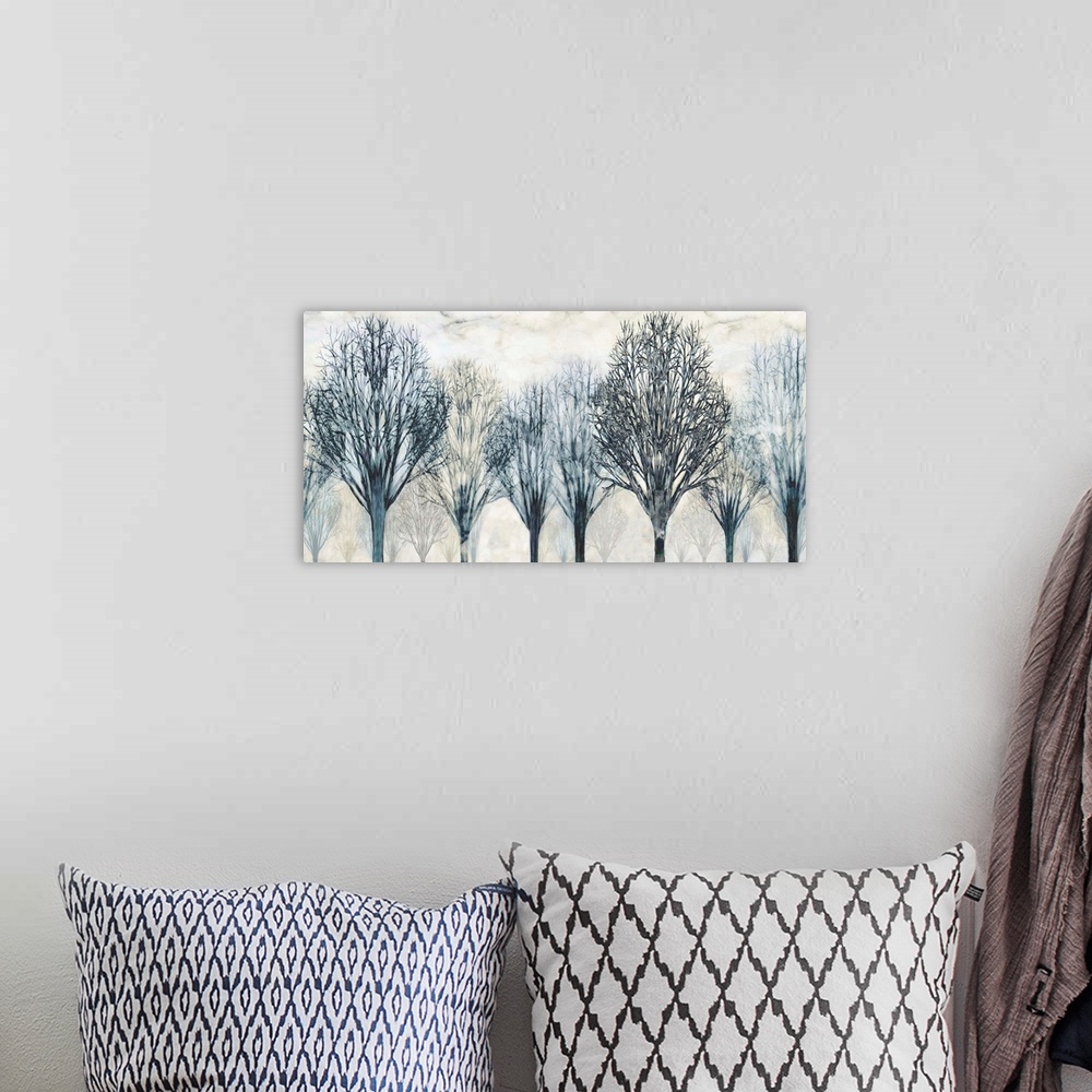 A bohemian room featuring Large artwork with Winter trees in dark blue and gray hues with a foggy background.