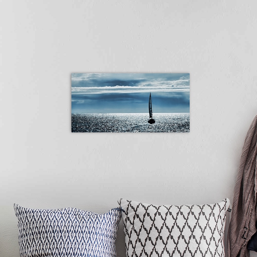 A bohemian room featuring Silhouettes of a yacht sailing alone in the ocean to the horizon.