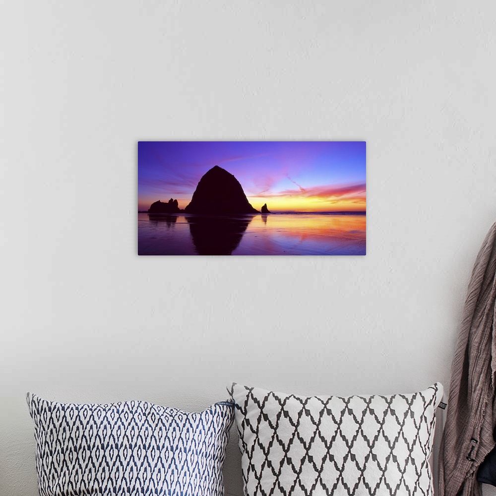 A bohemian room featuring Sea stacks on the beach silhouetted at sunset, Cannon Beach, Oregon.