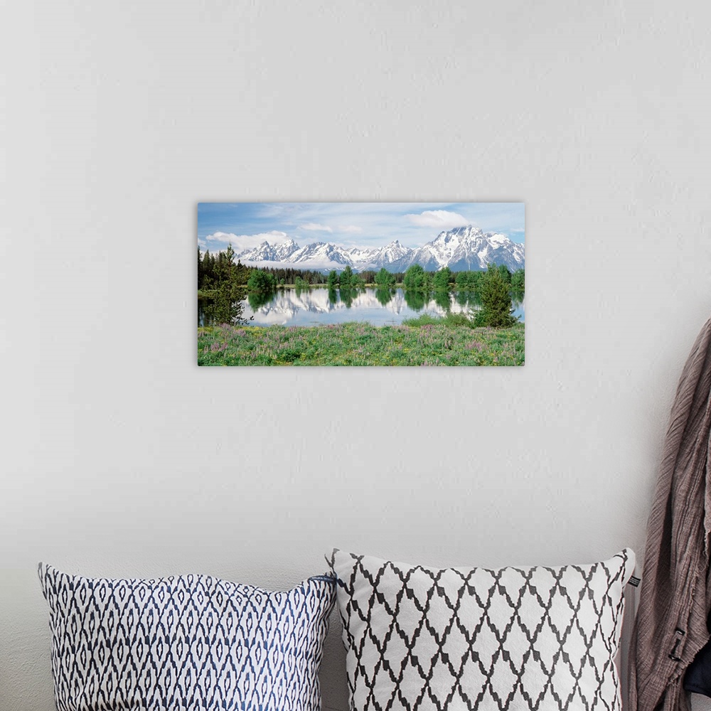A bohemian room featuring Large photo on canvas of a rugged mountain range with a lake in the foreground and a tree line se...