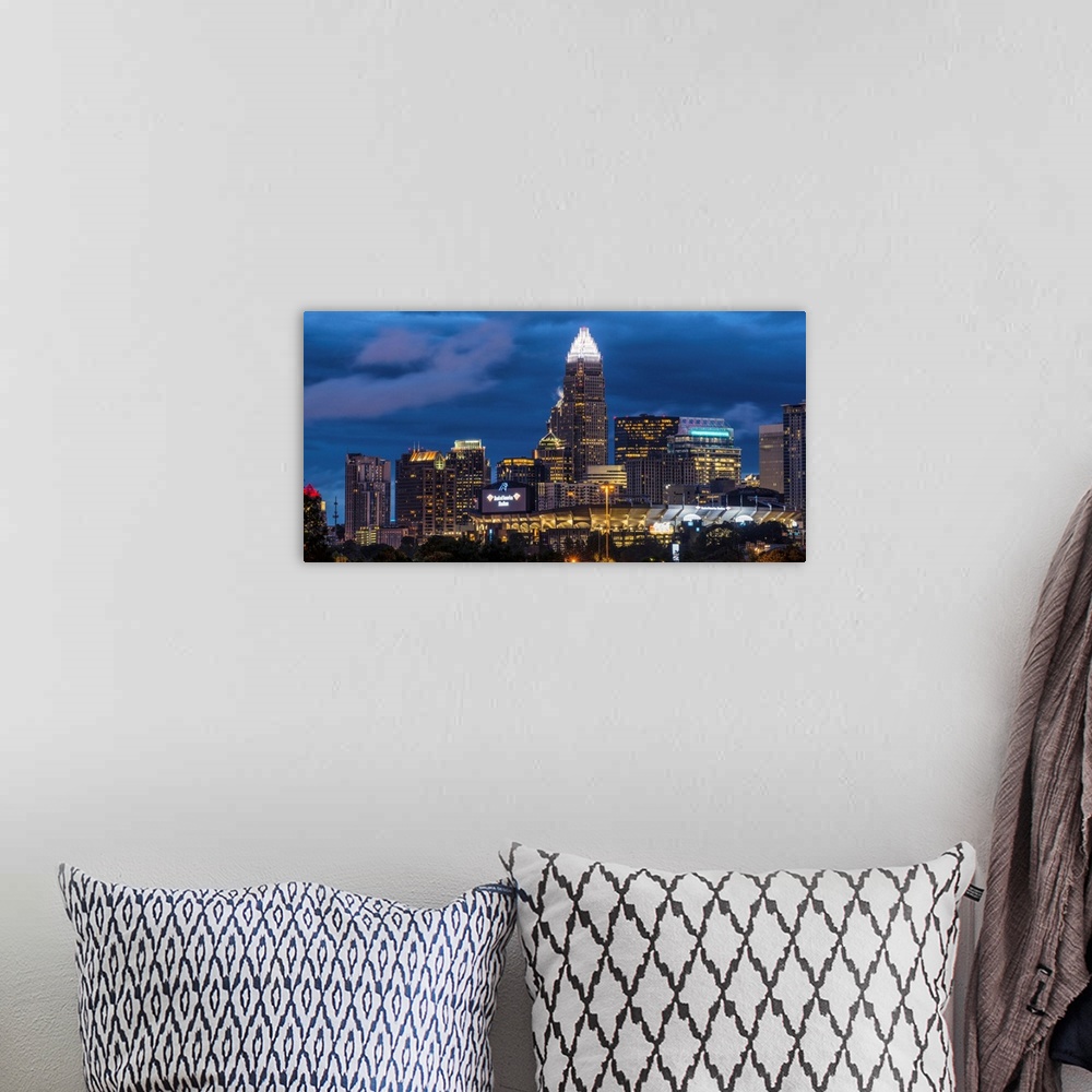 A bohemian room featuring A horizontal image of the Charlotte, North Carolina city skyline at night.