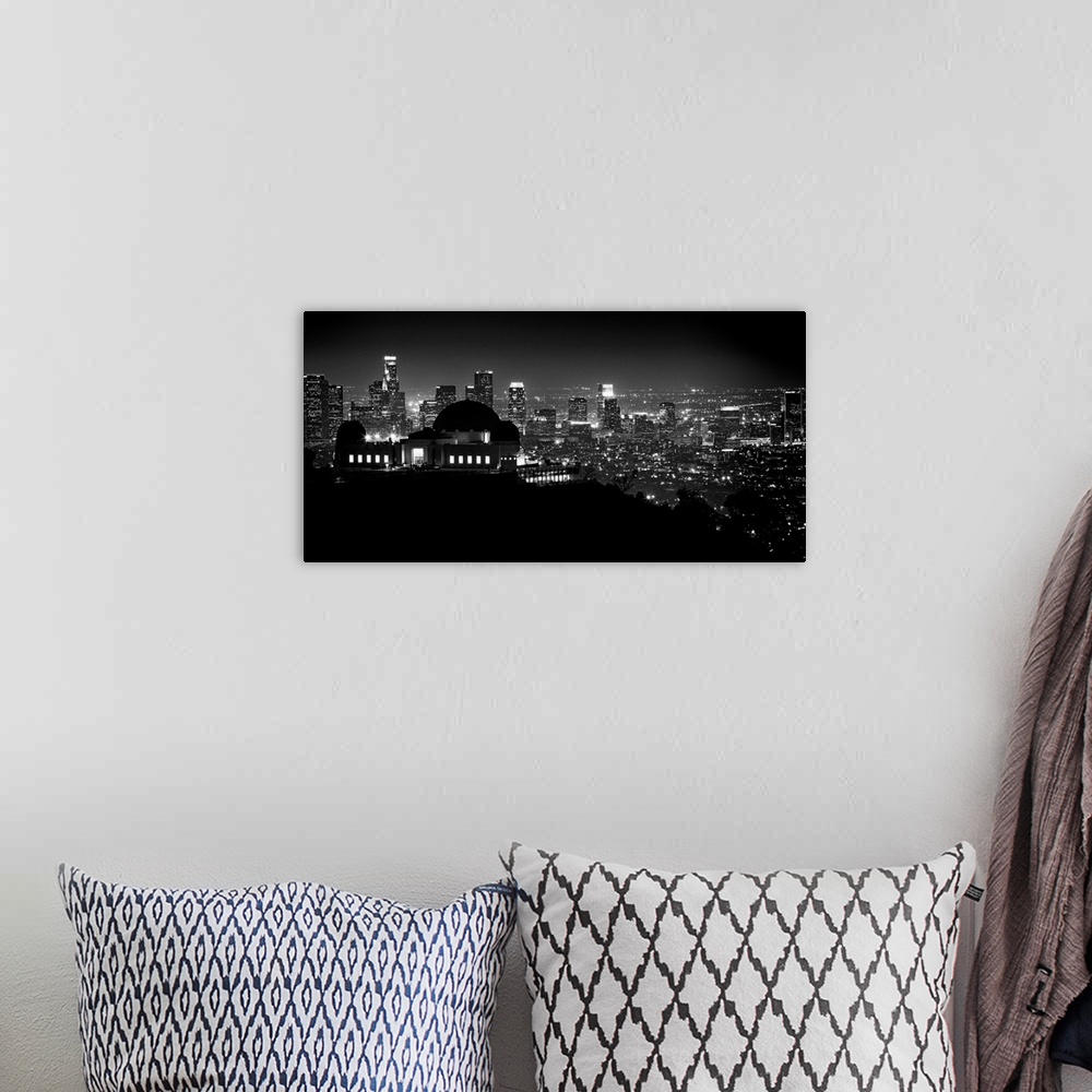 A bohemian room featuring Large monochromatic photograph displays the busy skyline of a famous California city at nighttime...