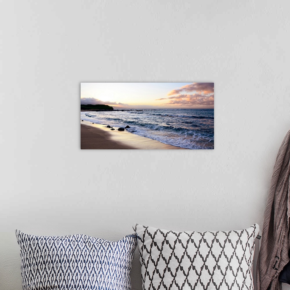 A bohemian room featuring A photograph of a pink and orange sunset on the beach.