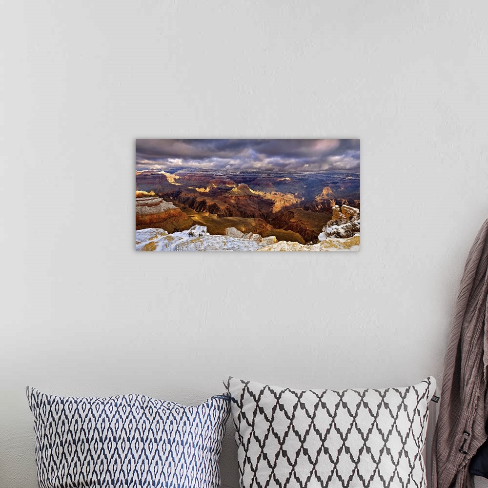 A bohemian room featuring Vista of the Grand Canyon in Arizona under a blanket of snow and dark storm clouds.