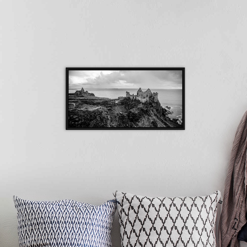 A bohemian room featuring Landscape photograph of Dunluce Castle next to the ocean, taken from a higher point.