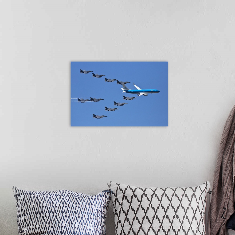 A bohemian room featuring A fleet of grey jets fly in formation around a blue commercial airliner.