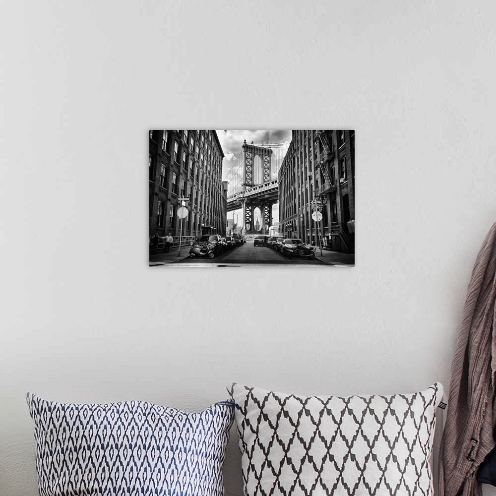 A bohemian room featuring A tower of the Manhattan Bridge framed by urban buildings in New York.