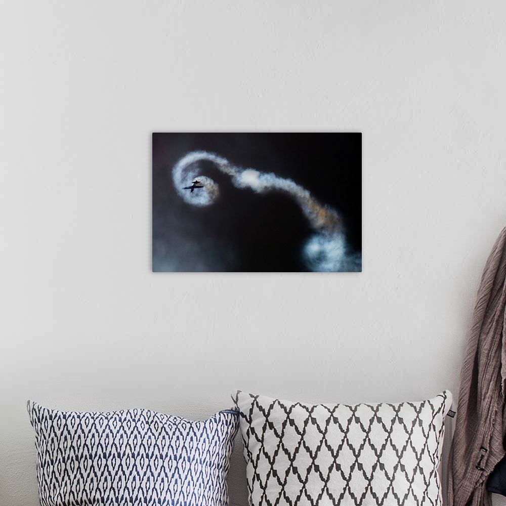 A bohemian room featuring An airplane leaves spiraling contrails, showing the loops it has just made.