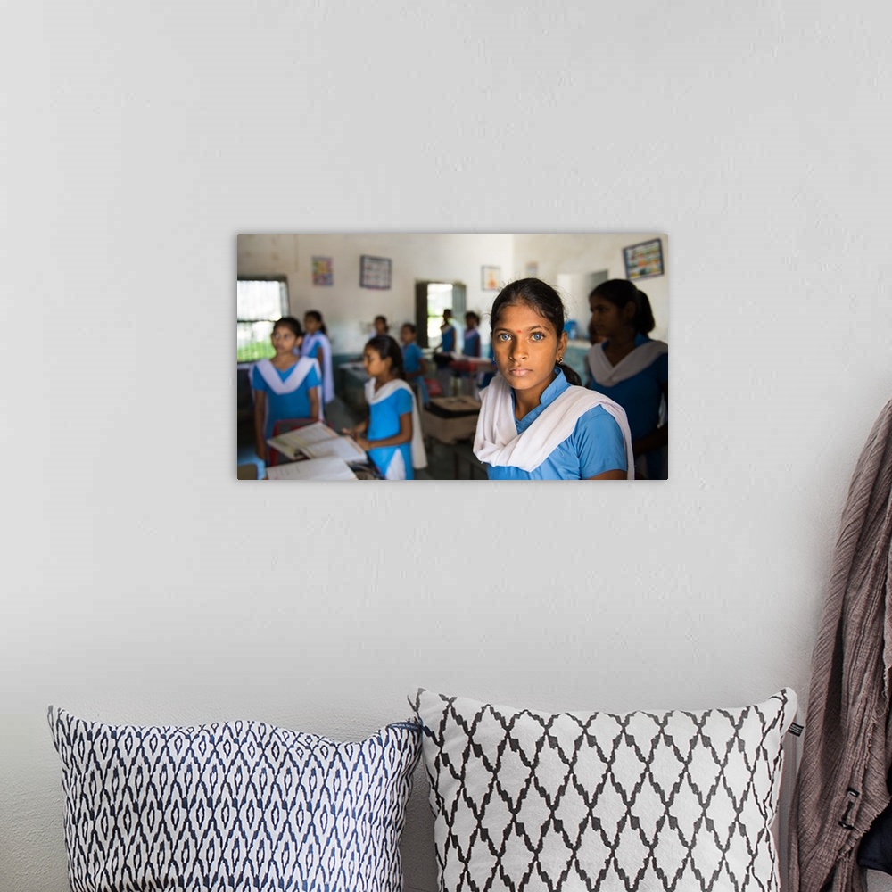 A bohemian room featuring A young Indian woman with deep blue eyes in a classroom.