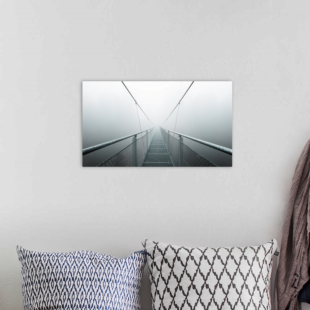 A bohemian room featuring Vanishing point view of the walkway and cables of a bridge, disappearing into the fog.