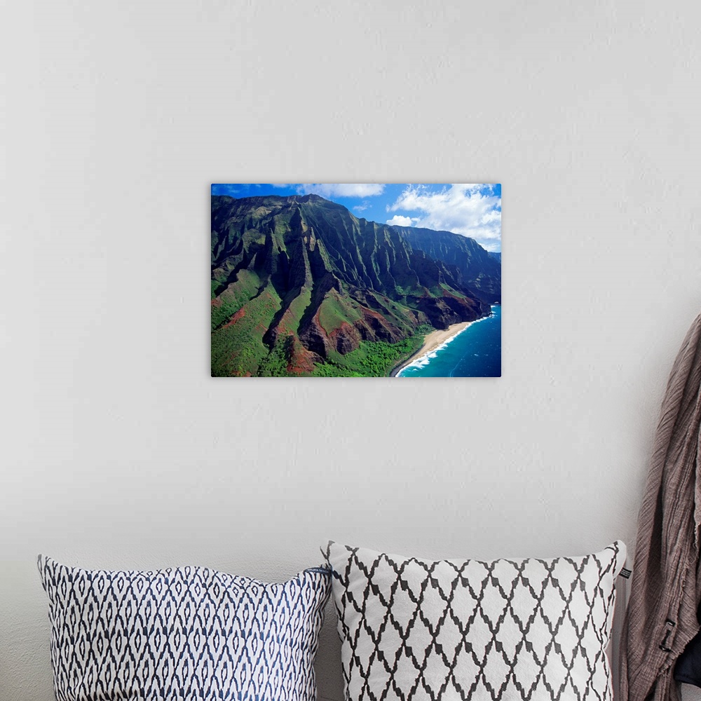 A bohemian room featuring This large piece is an aerial photograph of huge mountains on the coast of a Hawaiian island.