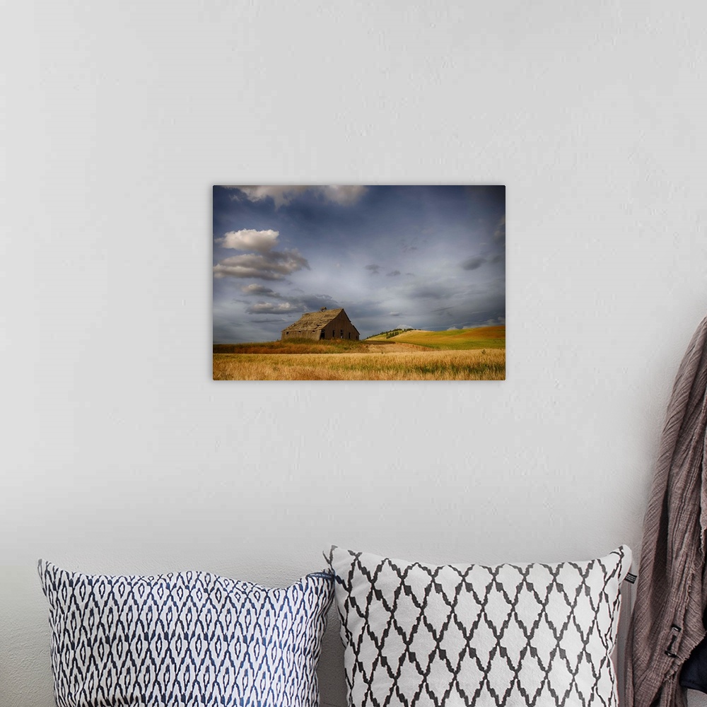 A bohemian room featuring Old wooden barn in a wheat field under a cloudy sky, Palouse, Washington, United States of America.