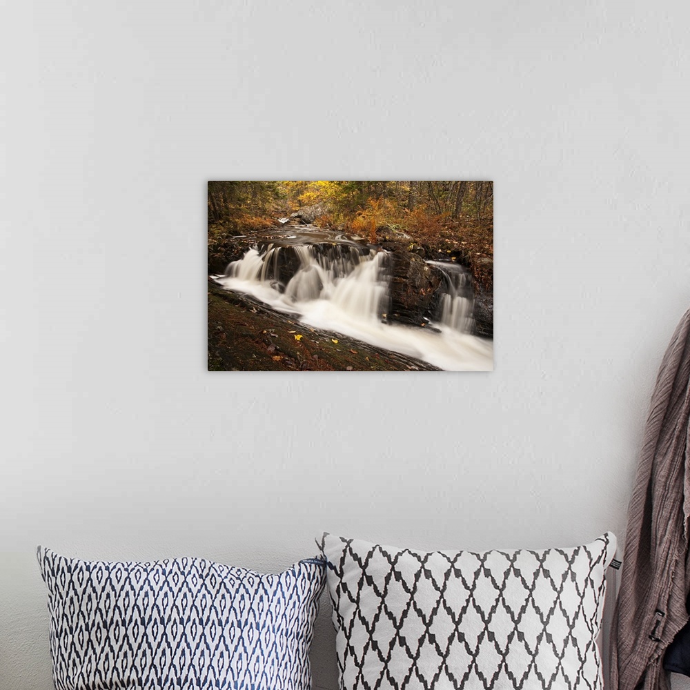A bohemian room featuring Waterfall on an autumn coloured landscape near Grand Lake; Nova Scotia, Canada