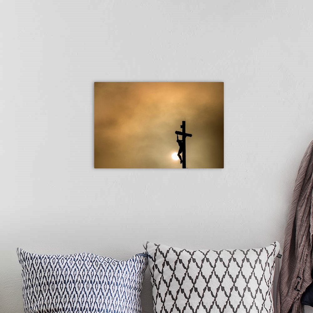 A bohemian room featuring Silhouette of Christ on the cross at sunset.