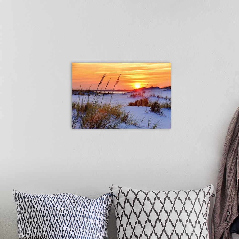 A bohemian room featuring Photograph of a orange and yellow sunset over sandy dunes on a beach.