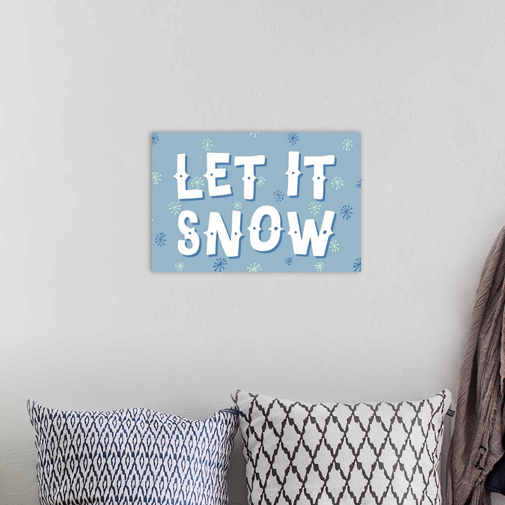 A bohemian room featuring Graphic holiday art with large text surrounded by snowflake graphics on a cool background.