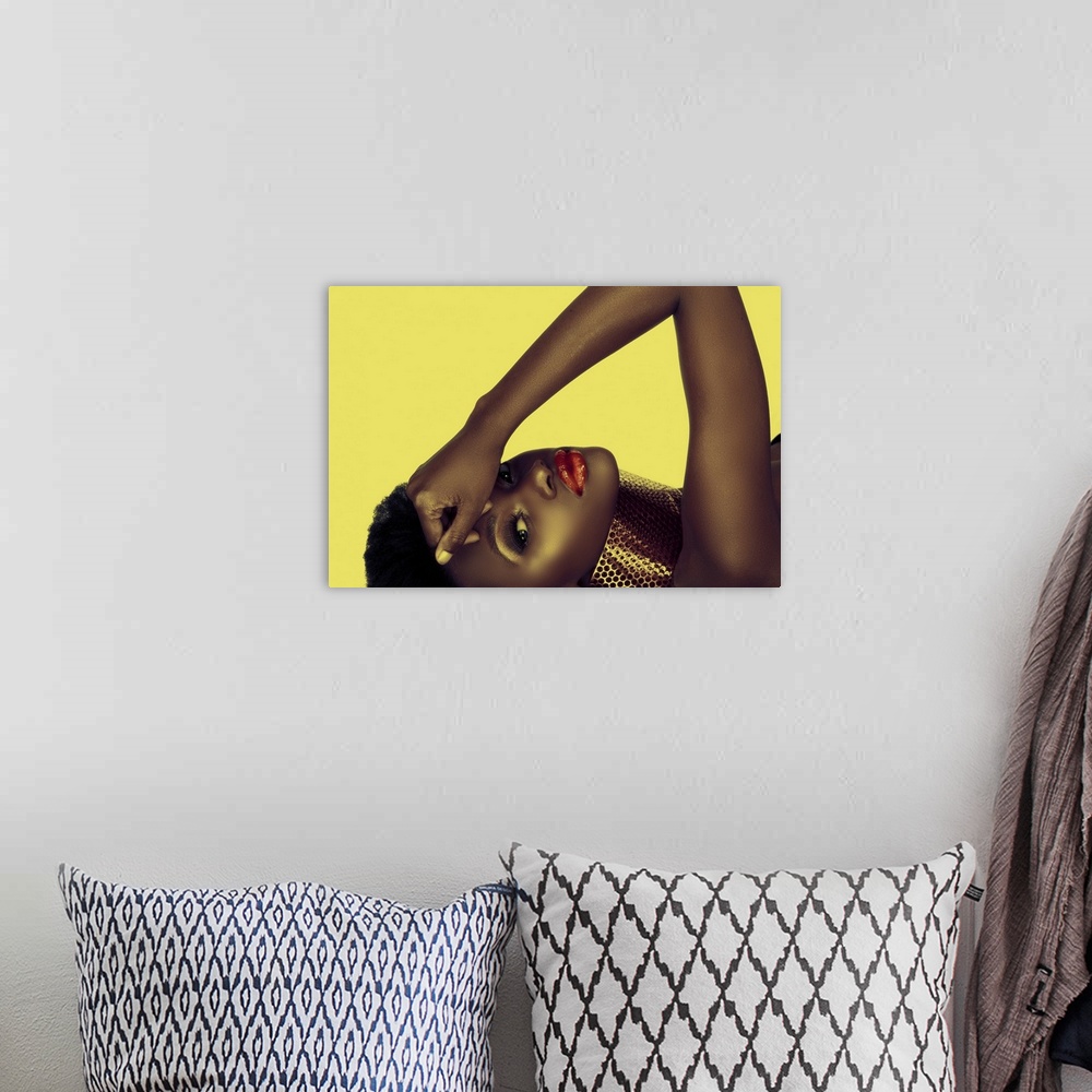 A bohemian room featuring Beautiful South African woman with bronze necklace and natural make-up on yellow background.