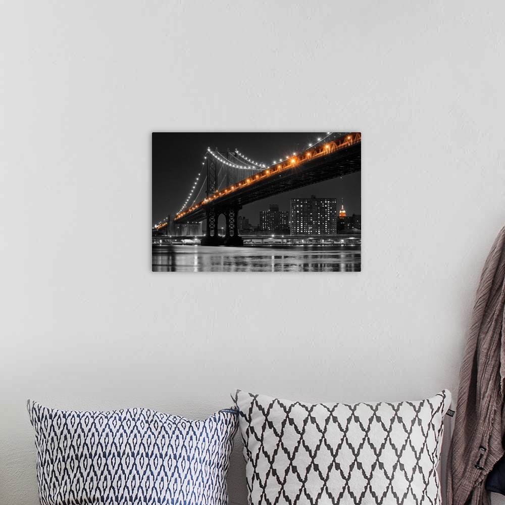 A bohemian room featuring Black and white photograph of the Manhattan Bridge at night with only the lights in color.
