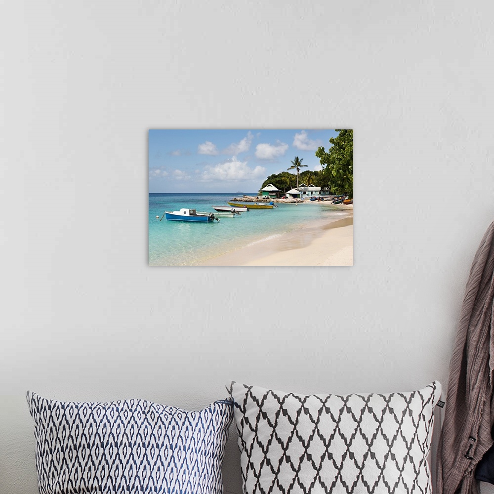 A bohemian room featuring Landscape photograph of blue Caribbean waters with anchored boats by the beach.