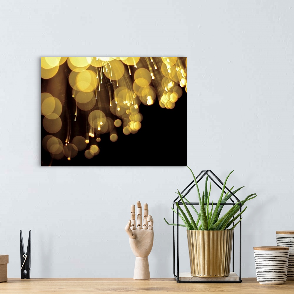 A bohemian room featuring Long exposure abstract photograph of gold lights with a black background.