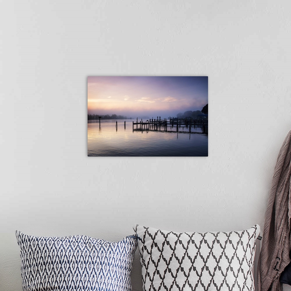 A bohemian room featuring Silhouetted pier on a calm ocean in pastel sunrise light.