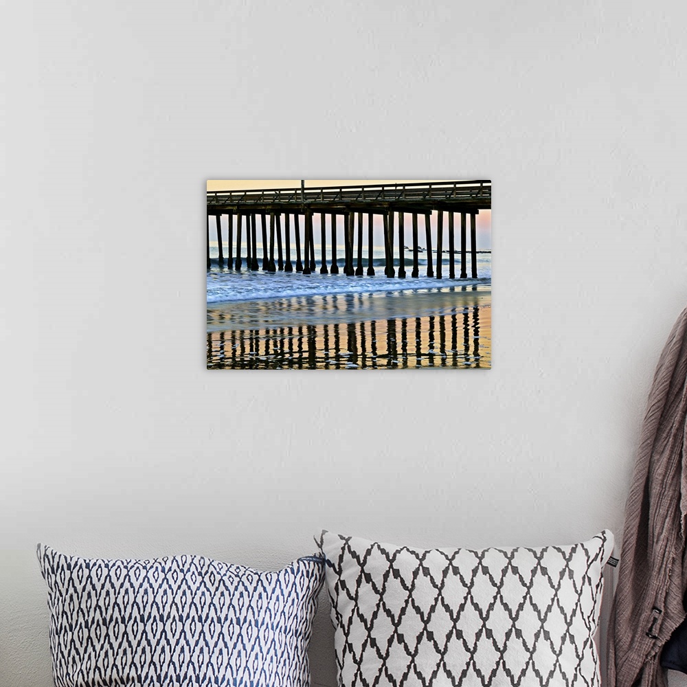 A bohemian room featuring Cayucos Pier silhouette and reflections onto the water at sunset.