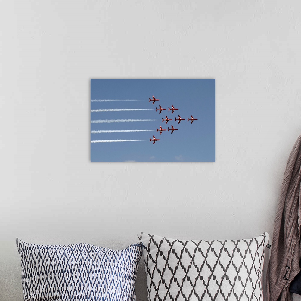 A bohemian room featuring A dramatic view of the Red Arrows Formation Aerobatic Flying Team performing at the Royal Interna...