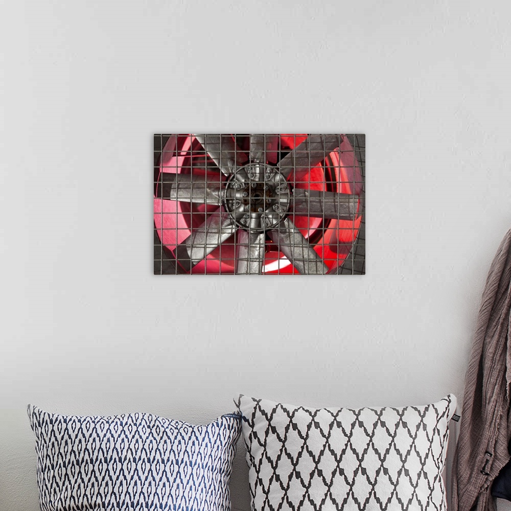 A bohemian room featuring Close up of industrial fan behind metal grate