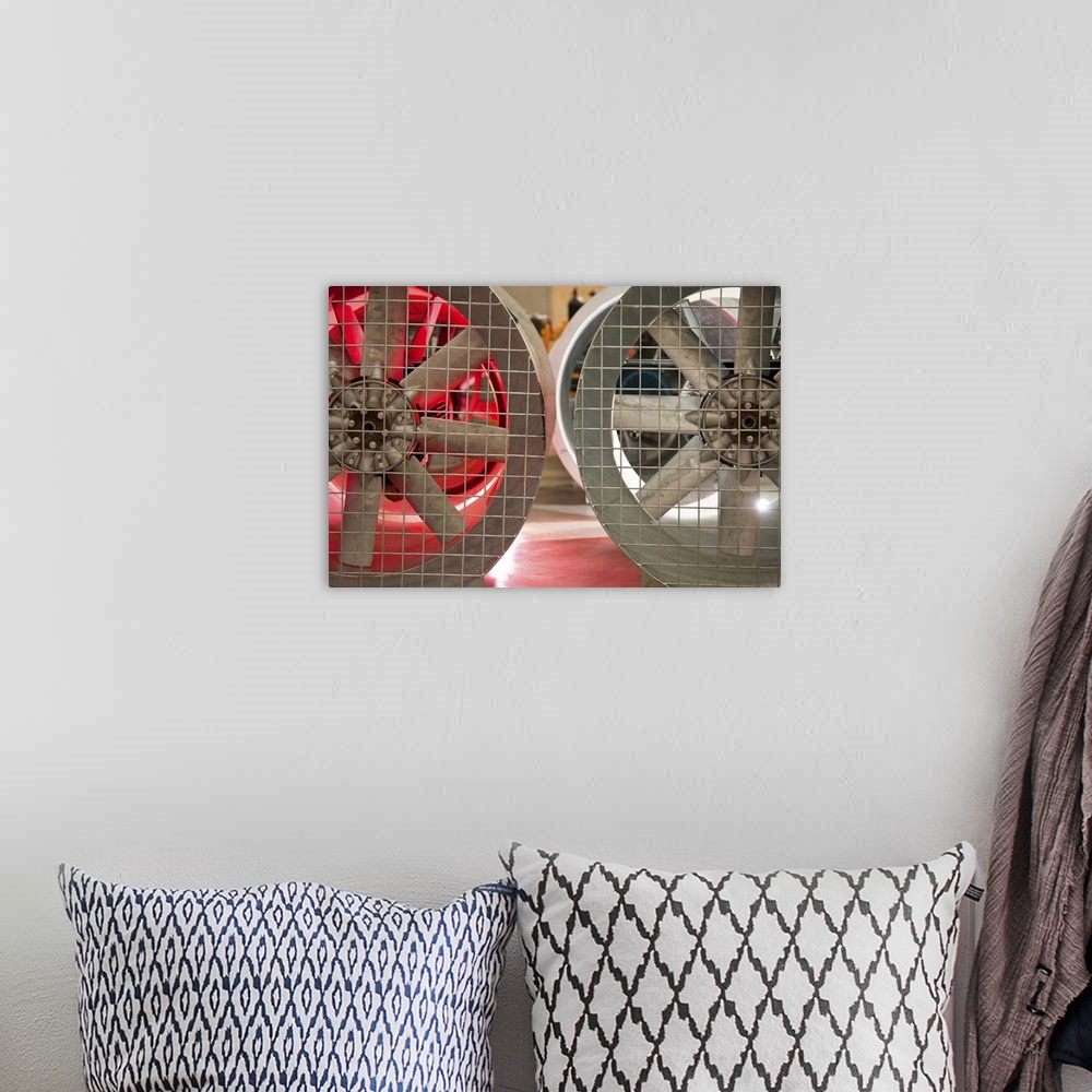 A bohemian room featuring Close up of industrial fans behind metal grate
