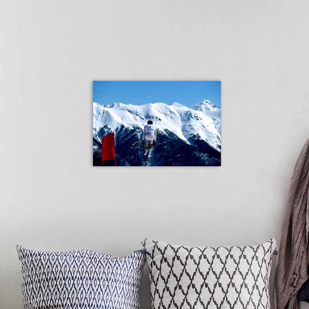 A bohemian room featuring Downhill skier in mid-air jump, mountains in background, rear view