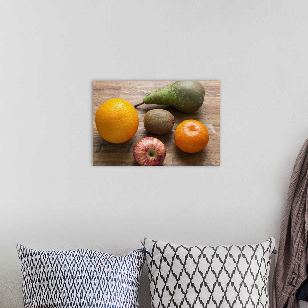 A bohemian room featuring Five mixed pieces of  fruit on a chopping board