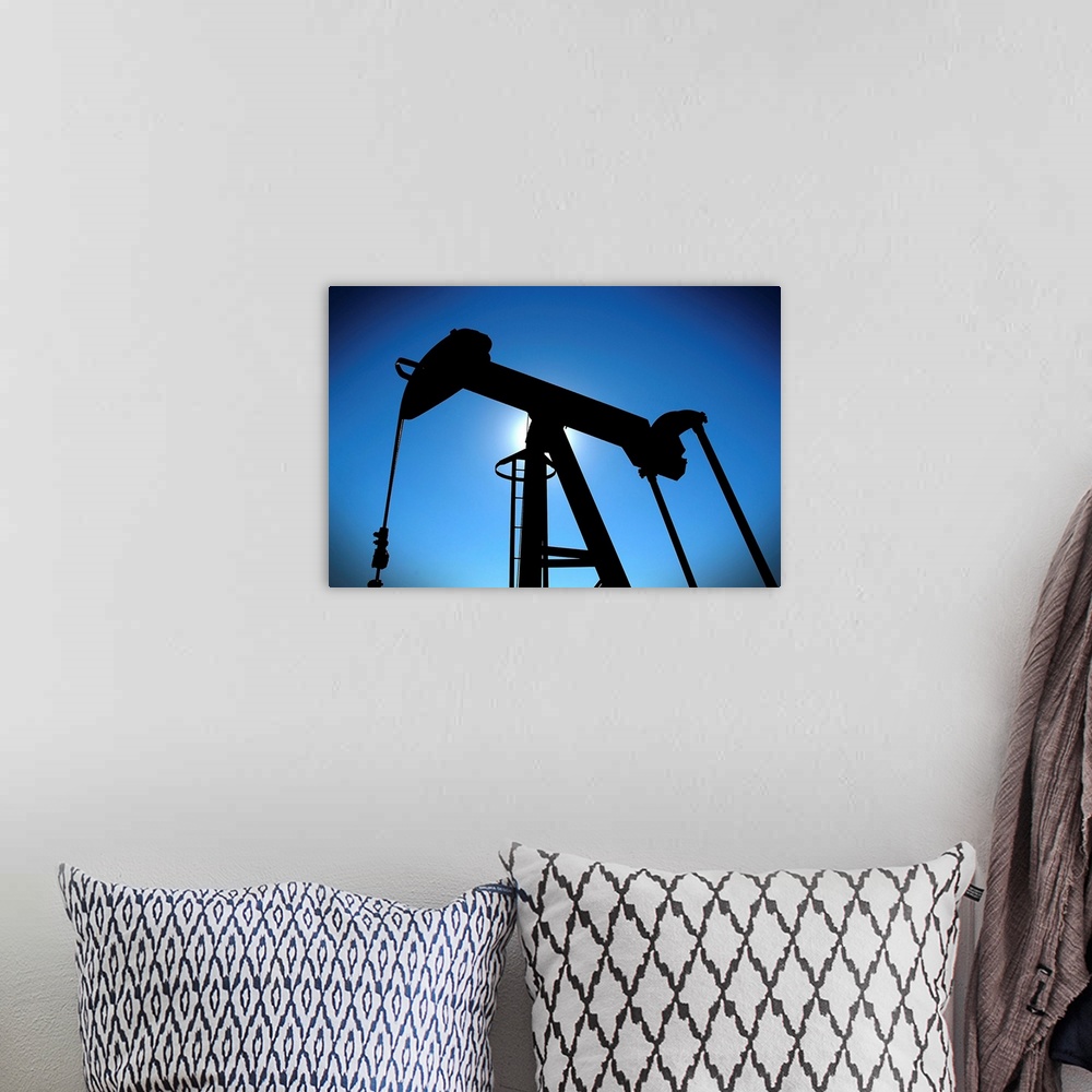 A bohemian room featuring Oil pump rig silhouetted on blue sky with heavy vignette.