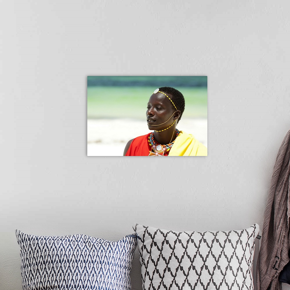 A bohemian room featuring Portrait of young tribal Masai warrior man on hot bright sunny African beach.