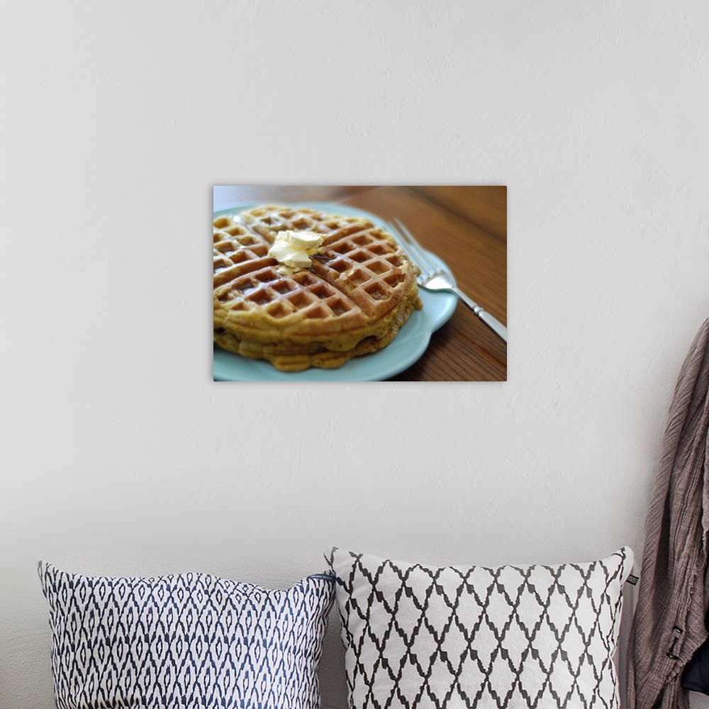 A bohemian room featuring Homemade pumpkin waffles on a blue plate for breakfast recipe with fork.