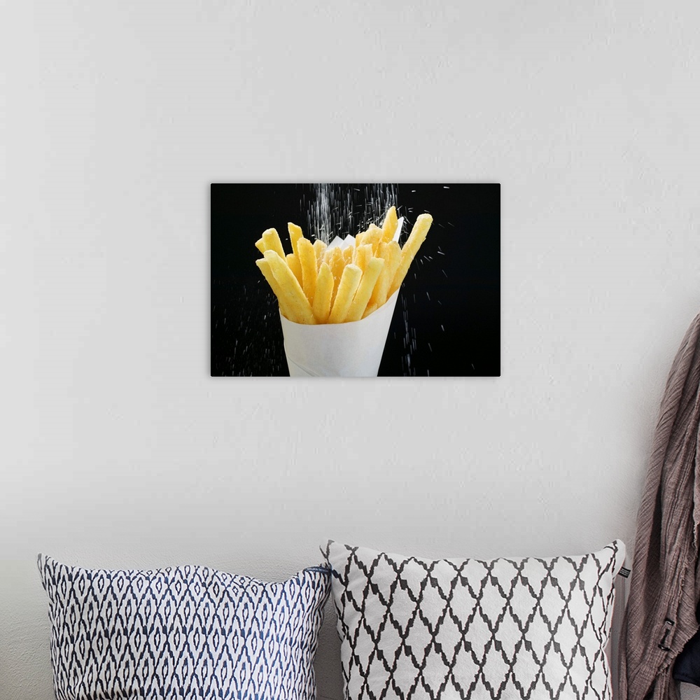 A bohemian room featuring Sprinkling salt on fries in paper cone