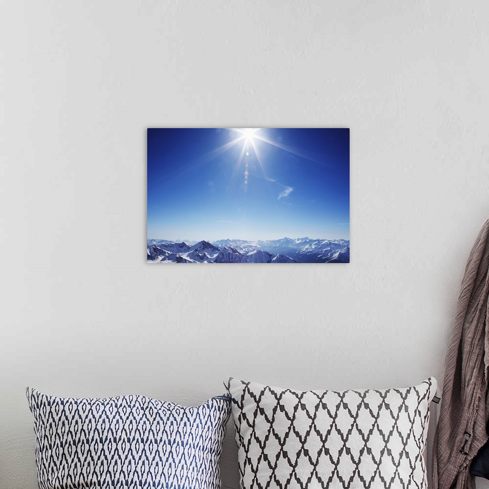A bohemian room featuring Sun over snow covered mountains