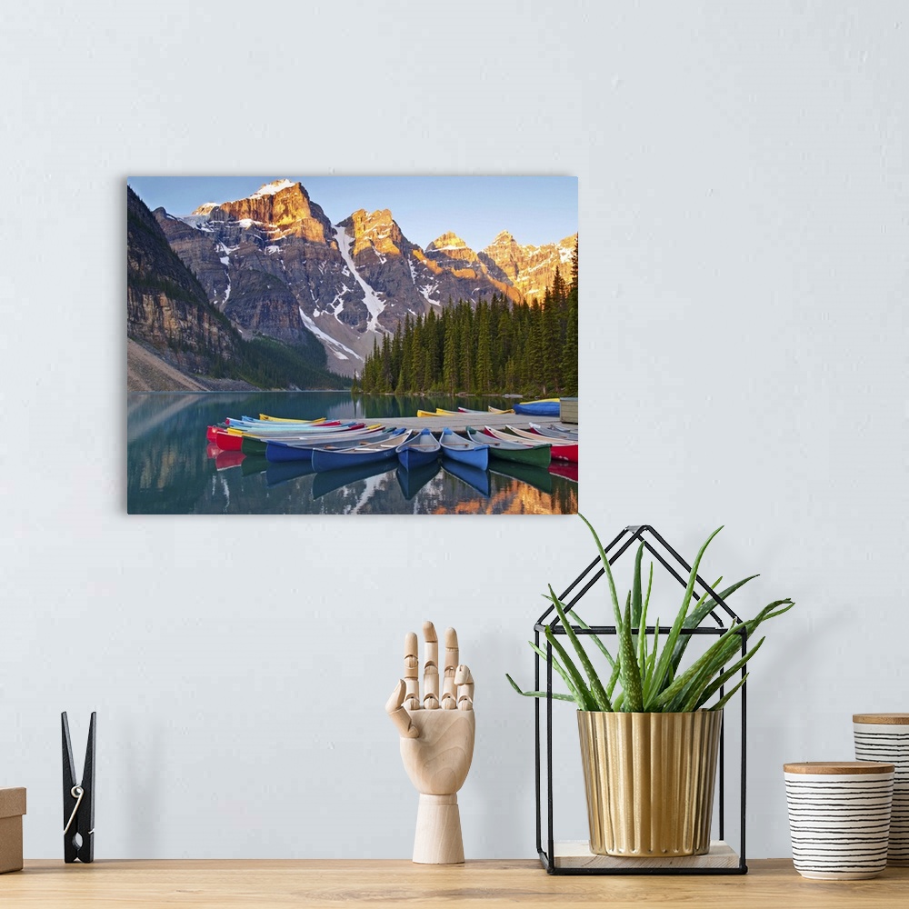 A bohemian room featuring Sunrise on Moraine Lake and colorful canoes in Banff National Park, Alberta, Canada.