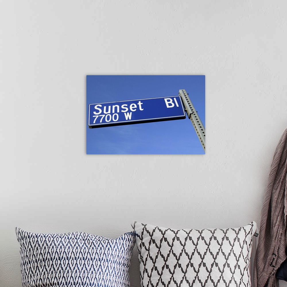 A bohemian room featuring Sunset Boulevard sign against a blue sky from a low angle.