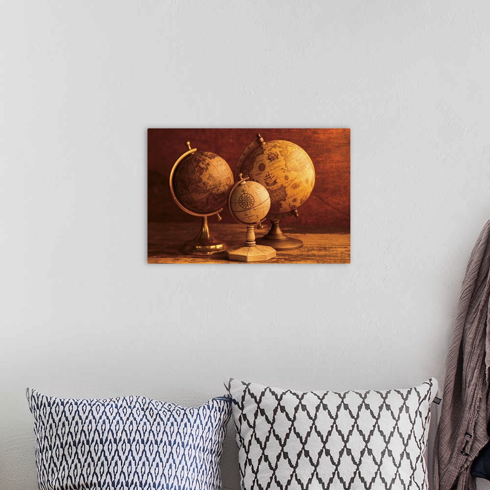 A bohemian room featuring Photograph of three vintage globes of varying sizes sitting on a map table.