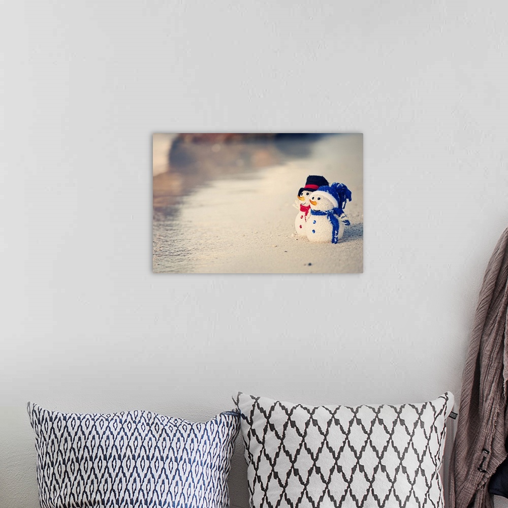 A bohemian room featuring Christmas time in warm weather. Waves on the white sand. Two snowman looking out to sea. Christma...
