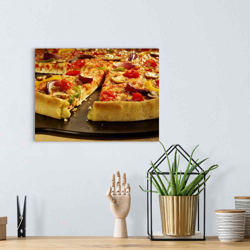 A bohemian room featuring Vegetable pizza sliced on black pan on wood