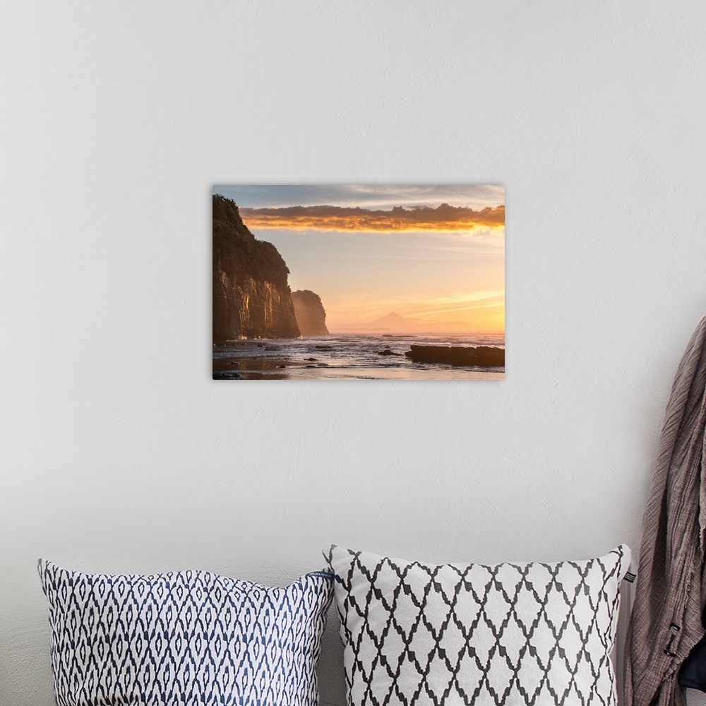 A bohemian room featuring Elephant rock and Mount Taranaki silhouette in the background, at sunset. Tongaporutu, New Plymou...