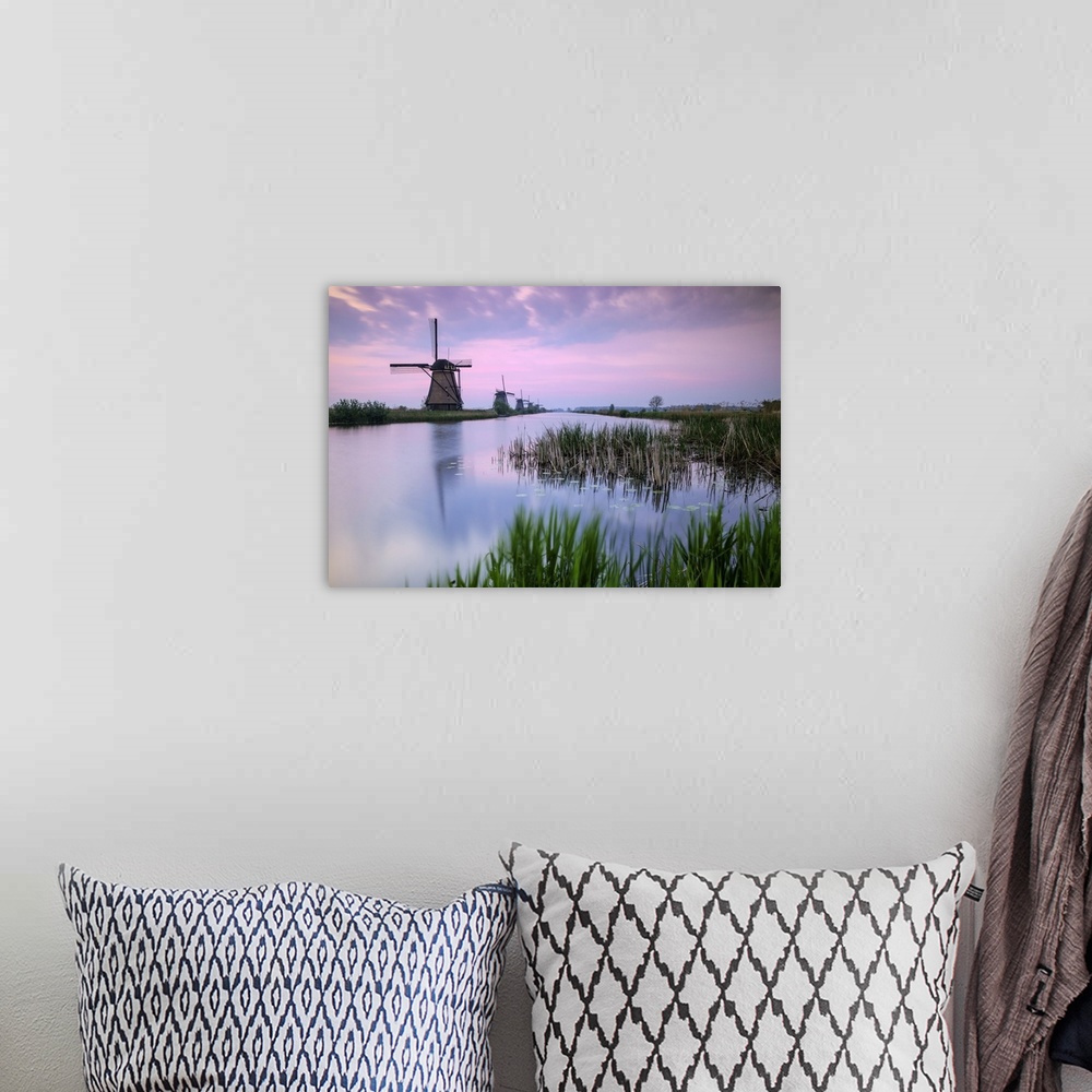 A bohemian room featuring Sky is tinged with purple at dawn on the windmills reflected in the canal Kinderdijk Rotterdam So...