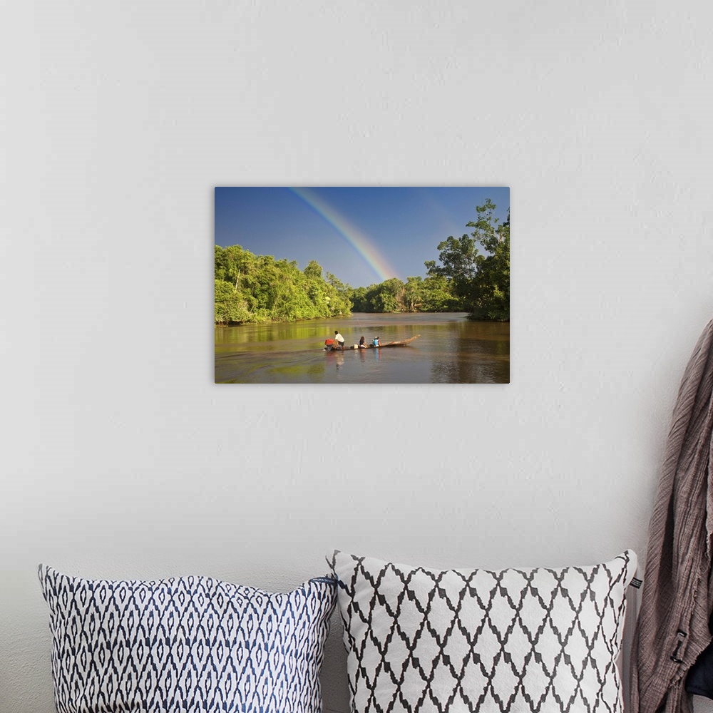A bohemian room featuring Venezuela, Delta Amacuro, Orinoco Delta, Warao People in boat on Nararina river with rainbow in s...