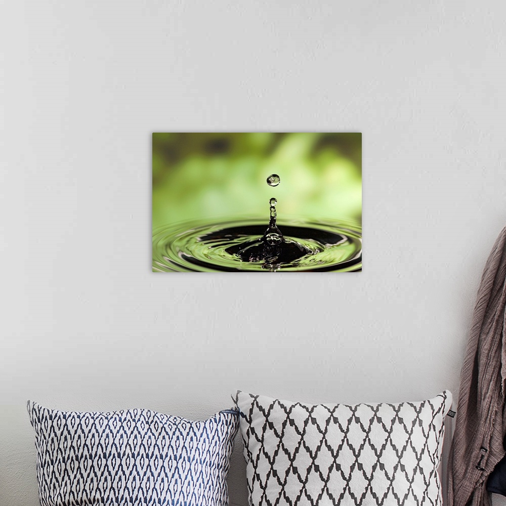A bohemian room featuring Horizontal photograph of drop of water frozen in the air and rippling in the surface below.