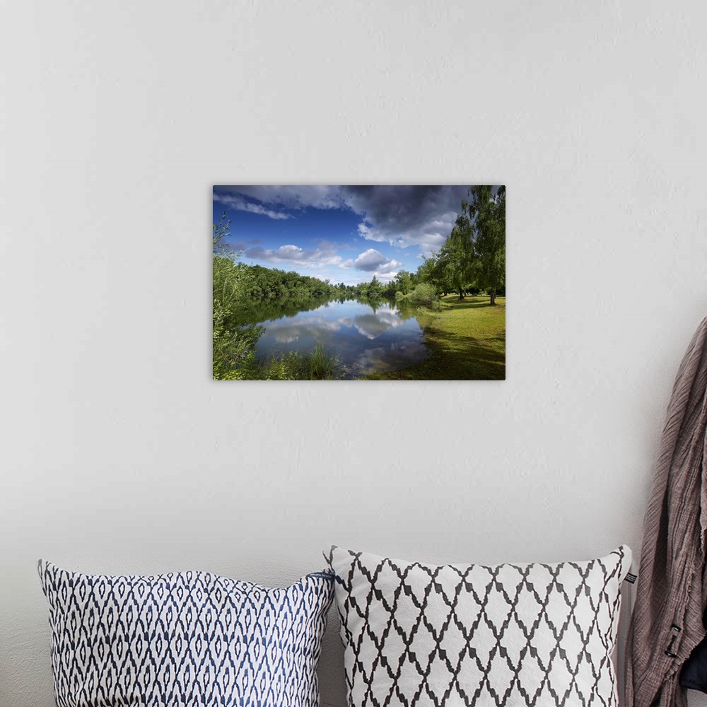A bohemian room featuring Tranquil landscape in summer by the water. Sky with big clouds