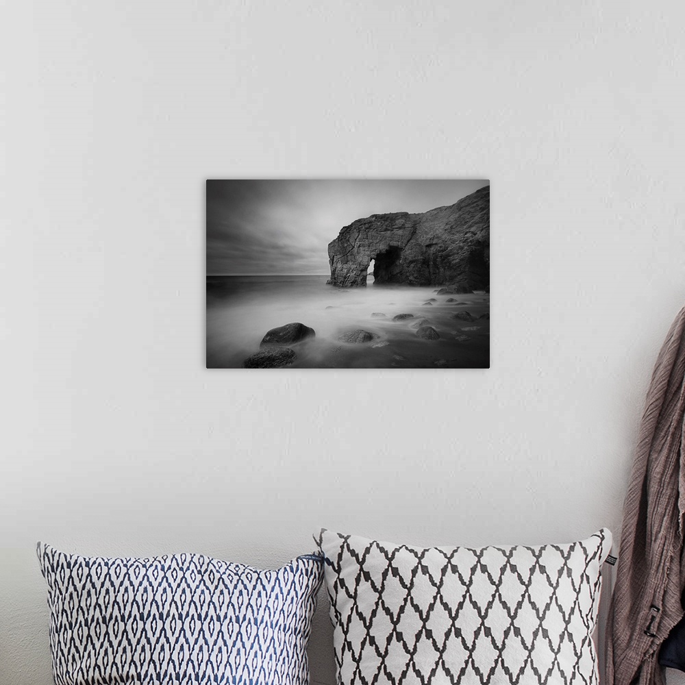A bohemian room featuring The natural arch rock in Quiberon island in Britany at high tide, a long black and white time exp...