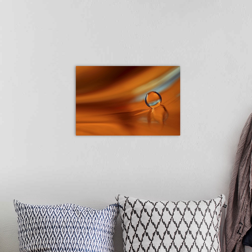 A bohemian room featuring A macro photograph of a water droplet sitting on an orange surface.