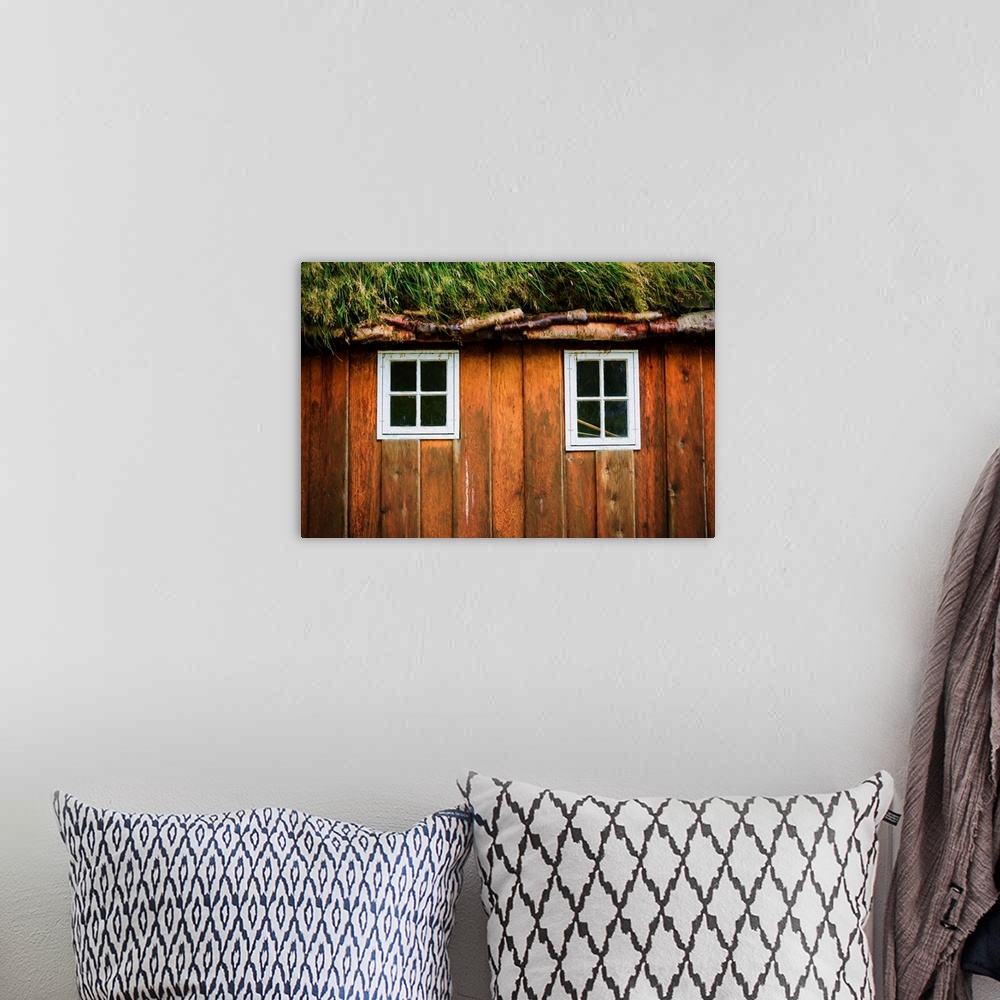 A bohemian room featuring Two little windows in a wooden wall with a grassy roof.