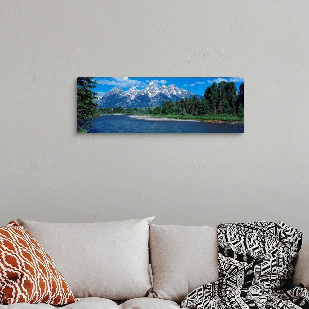 A bohemian room featuring Panoramic photo of rugged mountains in the background of a wide river cutting through the landsca...